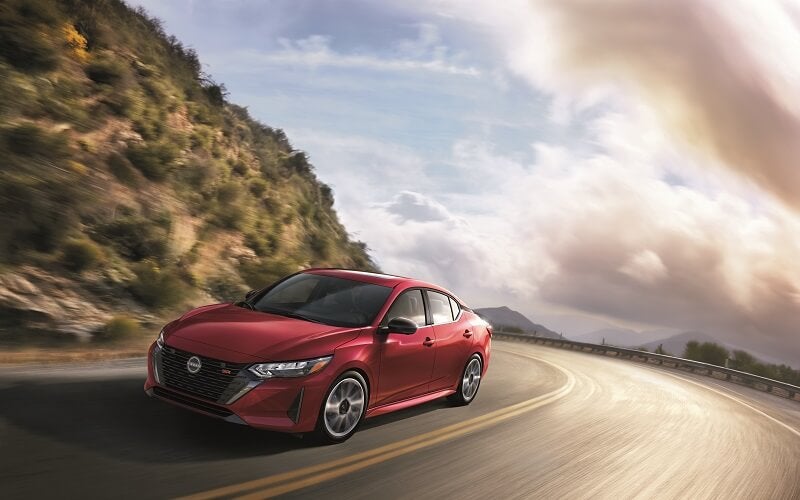Nissan Sentra driving on mountainside highway